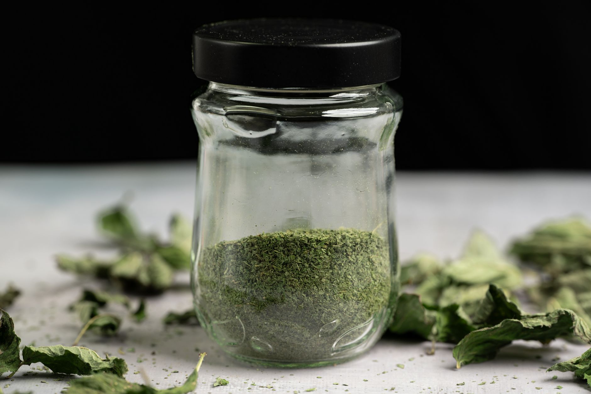 Jar of crumbled dried herbs ready for storage
