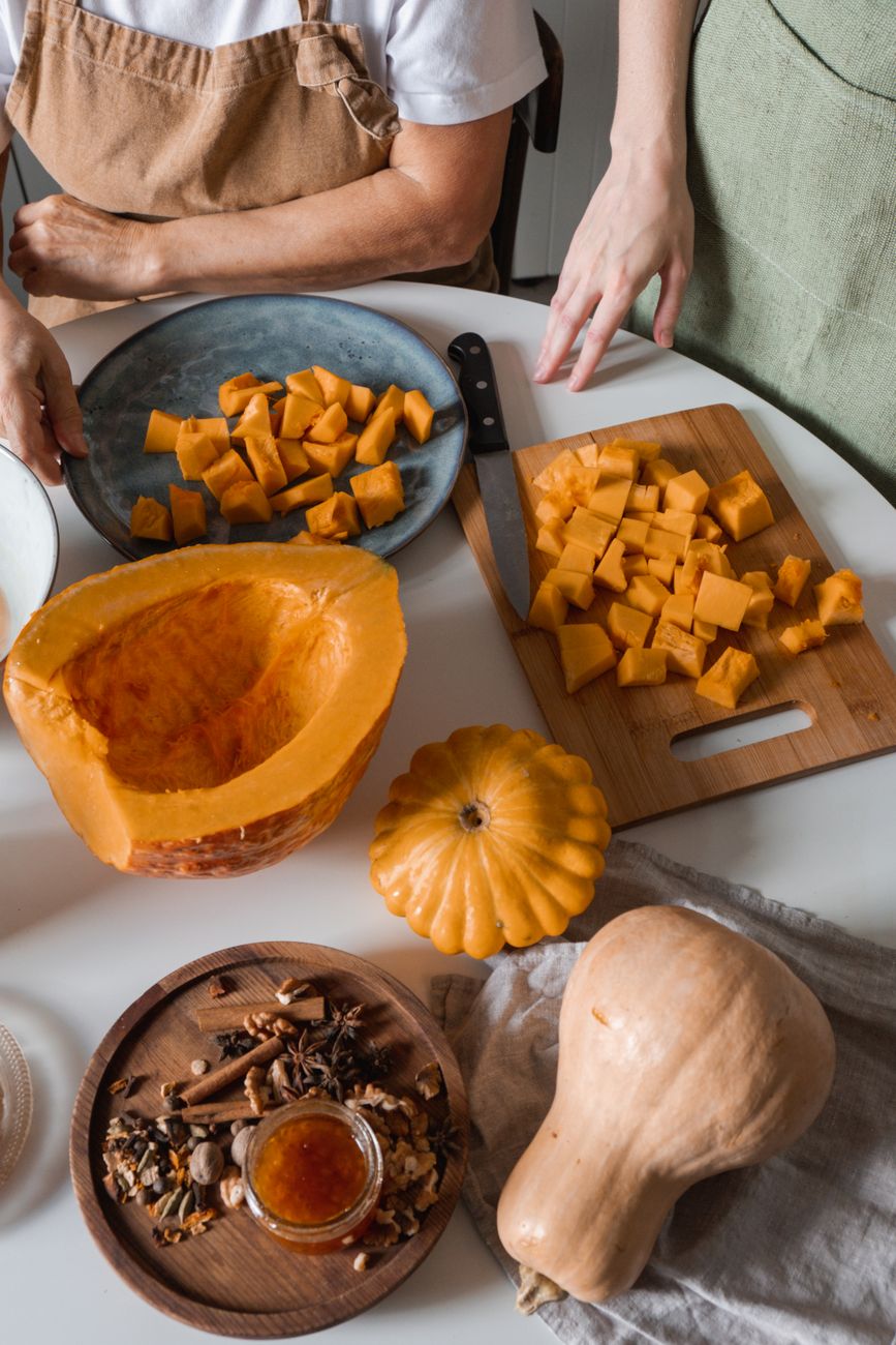 Cubed pumpkin and winter squash being prepared on a cutting board for canning